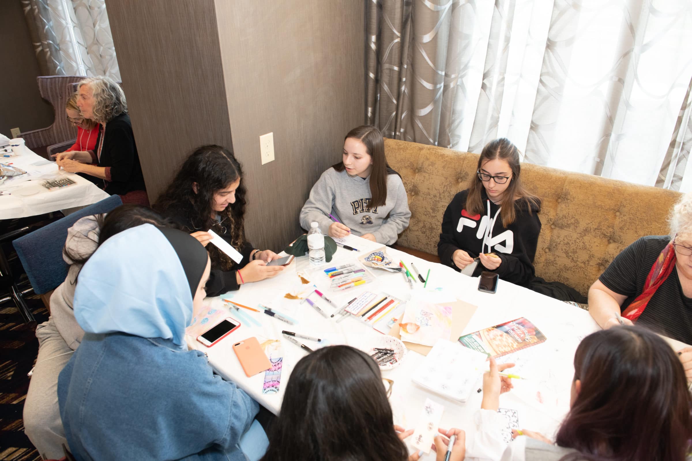 teens gathered around a table creating artwork