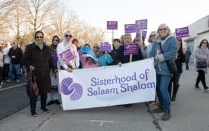 Sisters gathered with banner walking down street