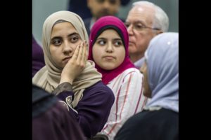 Women in hijab listening to a speaker