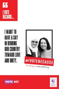 Woman in headscarf and sunglasses and smiling woman pose with banner saying I want to have a say in bending my country toward love and unity.